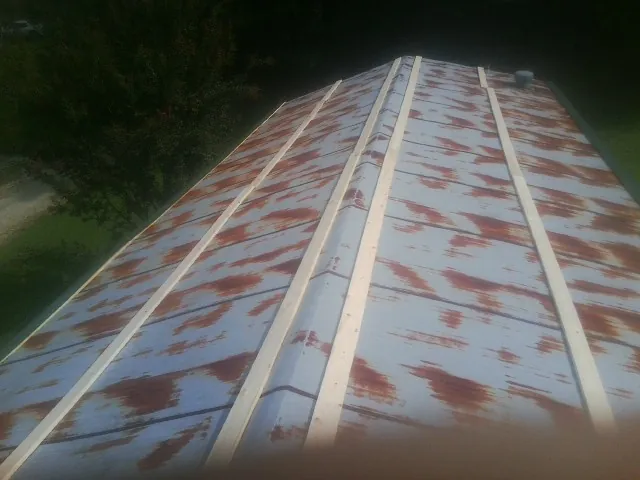 Rusted metal roof panels with new wood purlins before replacement — Storm Damage Roof Repair in Cornersville by Roofing Brothers