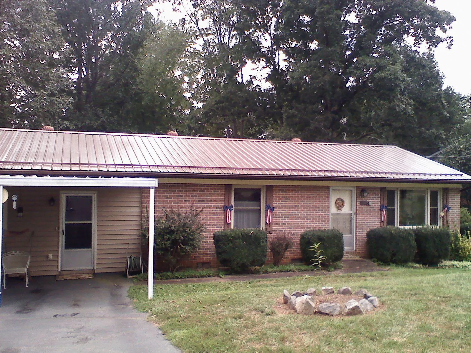 Bronze metal roof and carport on a brick ranch home — Roof Repair work by our crew in Cornersville